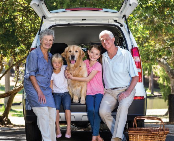 family sitting on trunk of van